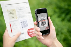 Someone using a mobile phone to scan a QR code in magazine symbolising changing technologies.