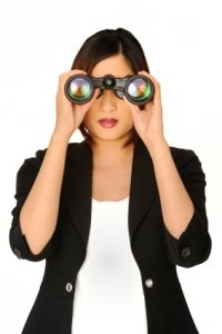 Women with binoculars symbolising emtrepreneur with vision.
